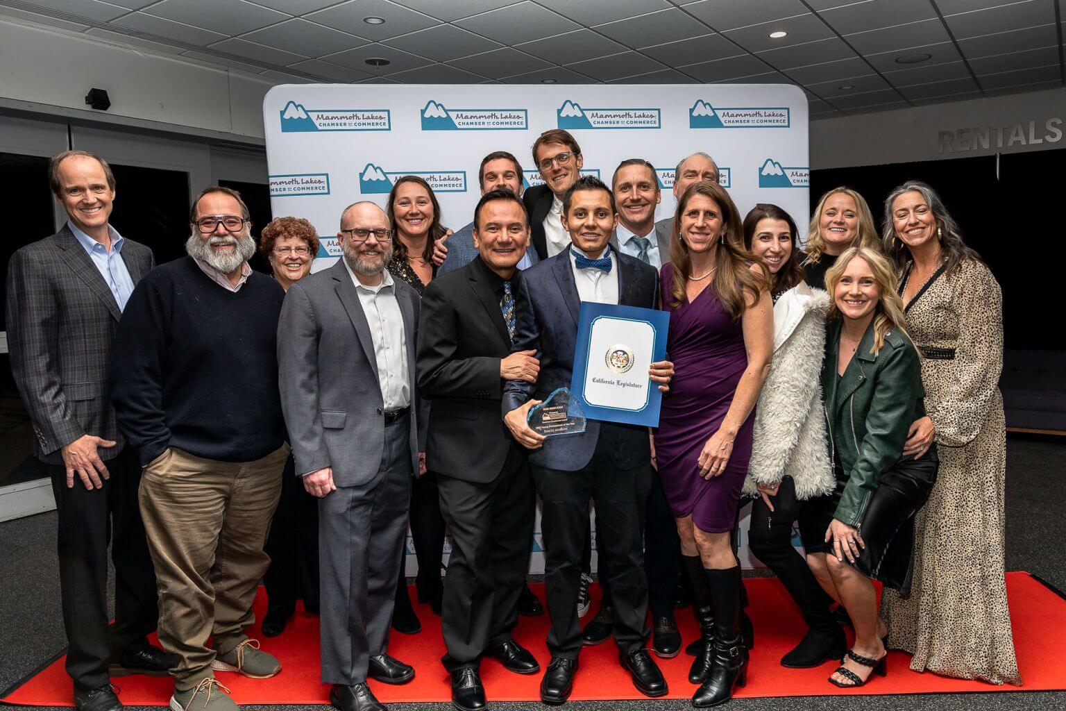 Mammoth Mountain employee Sergio Moreno poses with a large group of Mammoth Mountain staff after winning the Young Professional of the Year award
