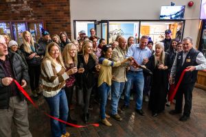 Peak IV owners and staff cut the ribbon with big scissors during their ribbon cutting ceremony