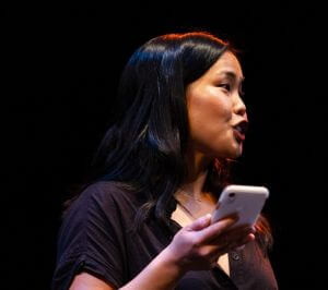 A grantee presents under stage lights