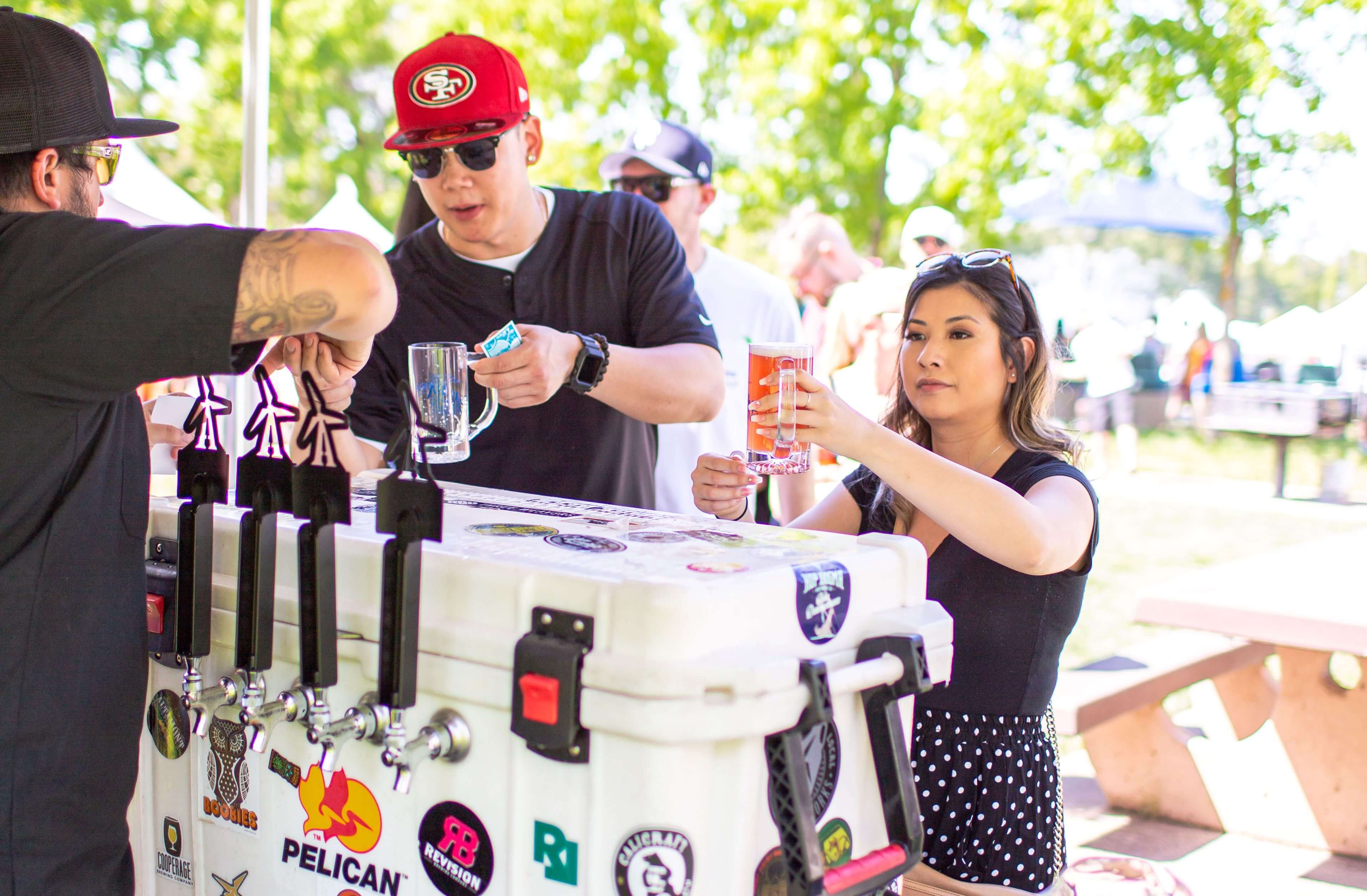 Two visitors to a beer pouring booth at the Art & Wine Festival