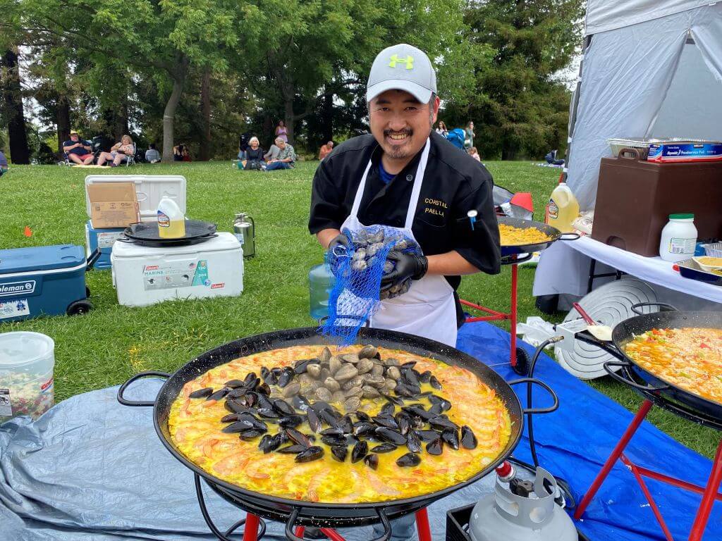 Man cooking large quantity of paella