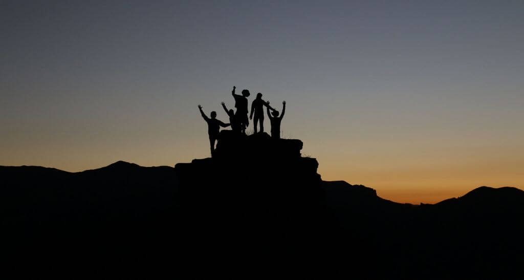 silhouette of people on a hill