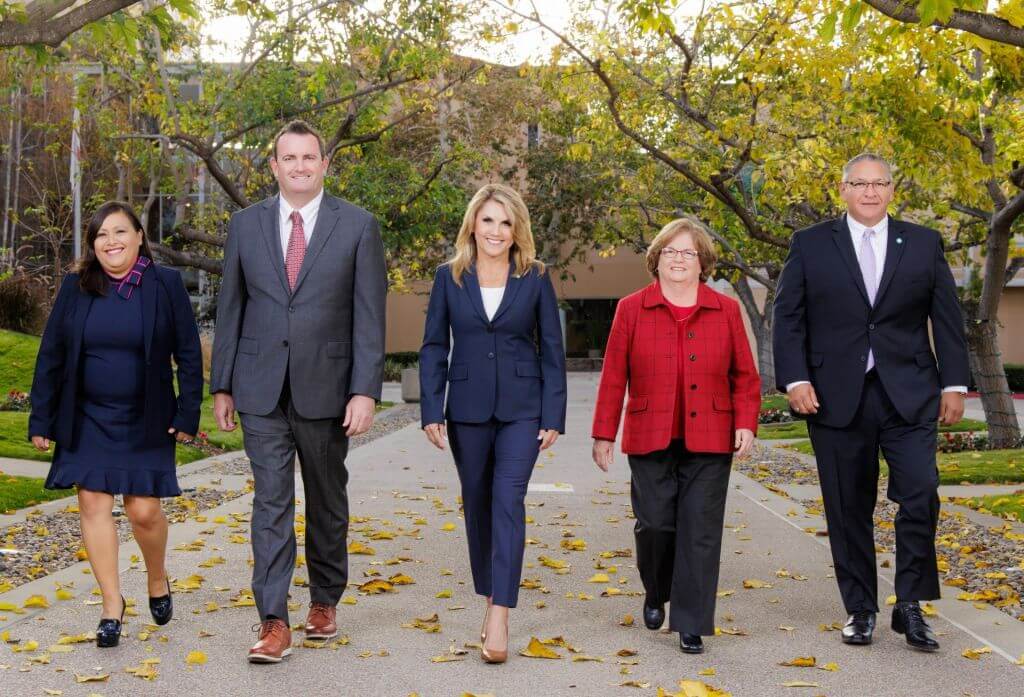 meet the elected officials -5 people walking down road with leaves