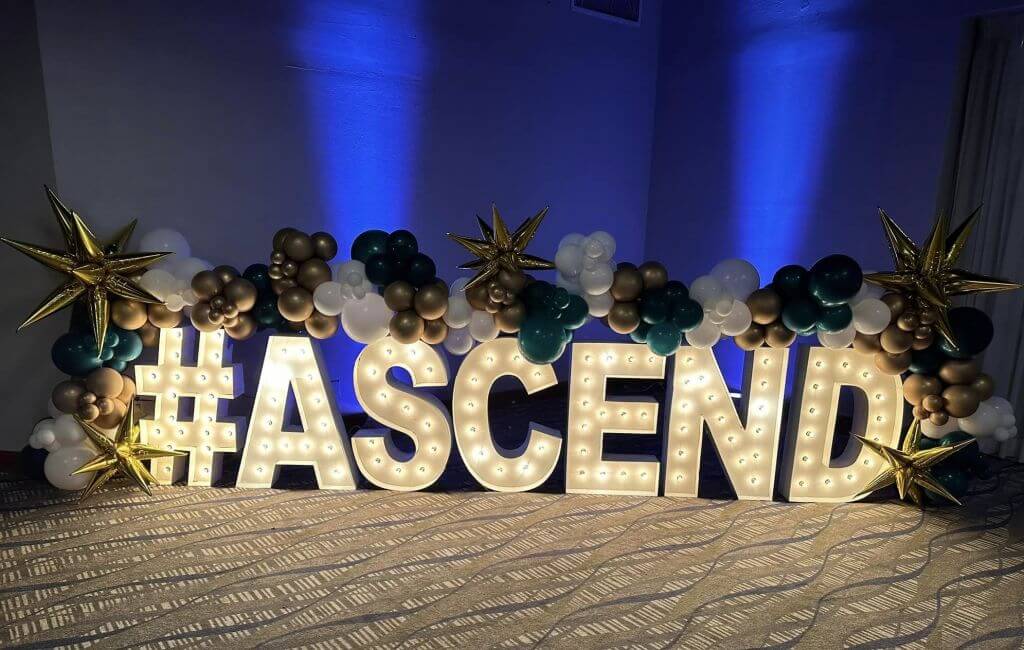 ascend word lit up and with balloons
