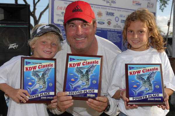 man and kids holding up KDW prize plaques