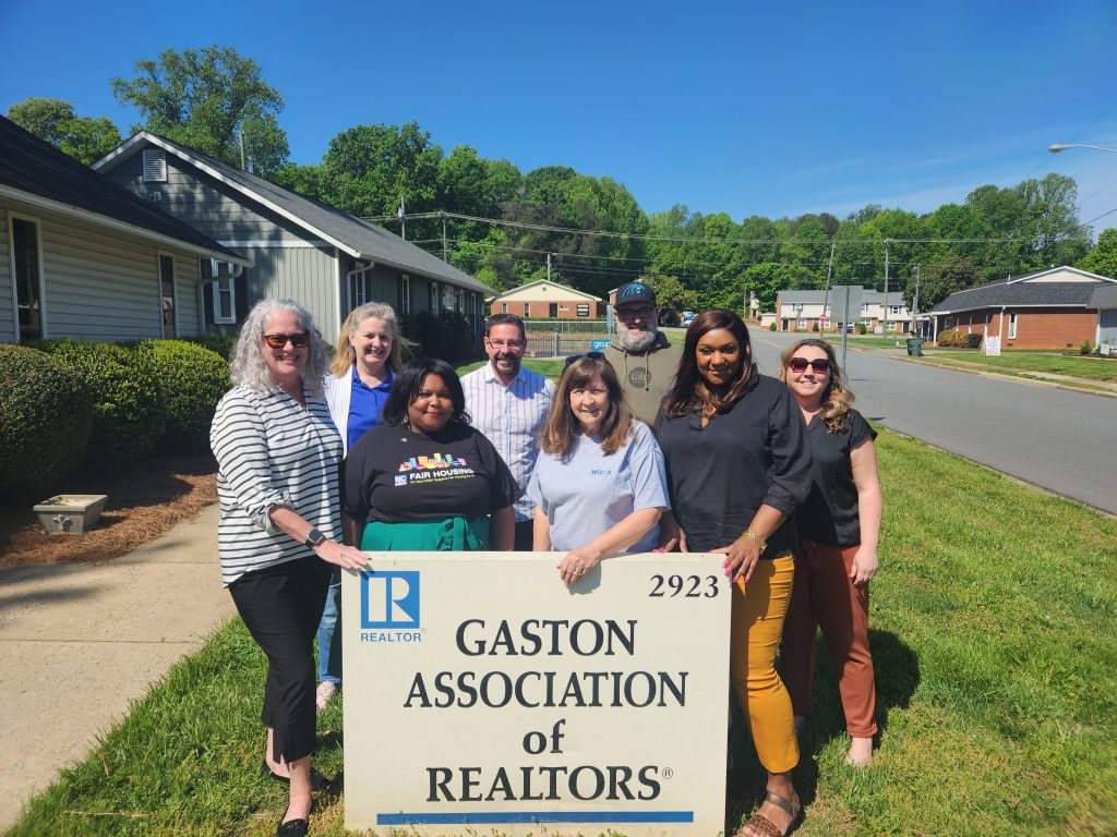BOD standing in front of gaston association of raltors sign