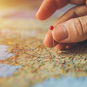 hand placing pin in a map