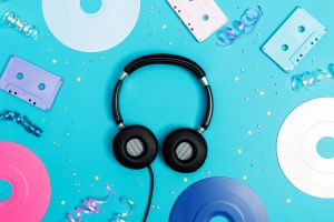 Music flat lay objects with vinyl records and cassette tapes on a blue background