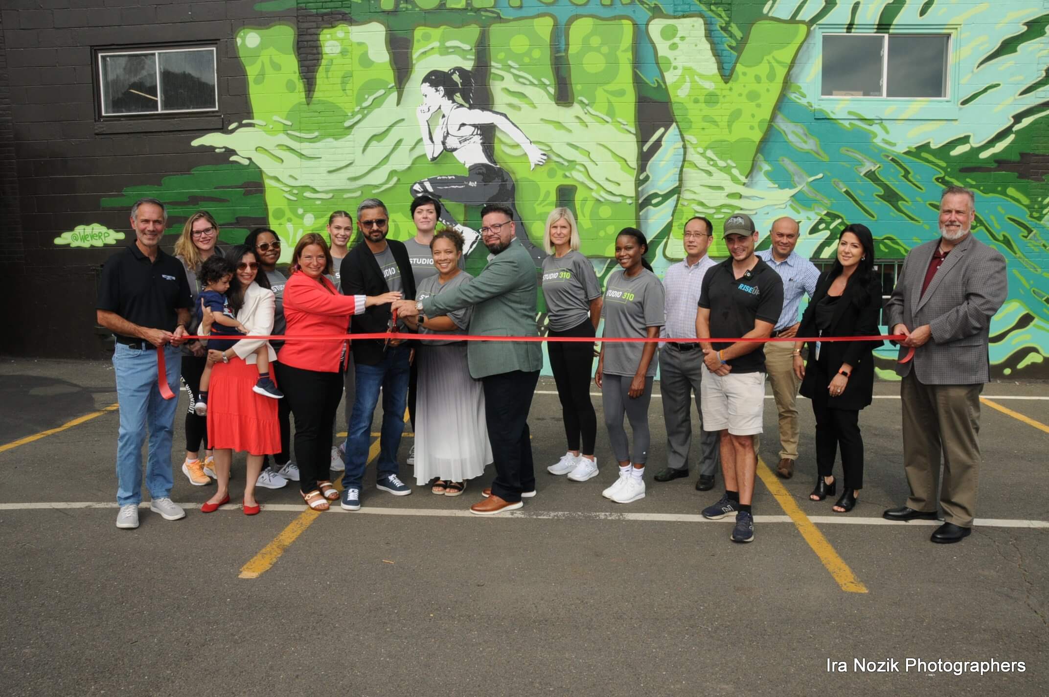 Ribbon Cutting in front of a large mural
