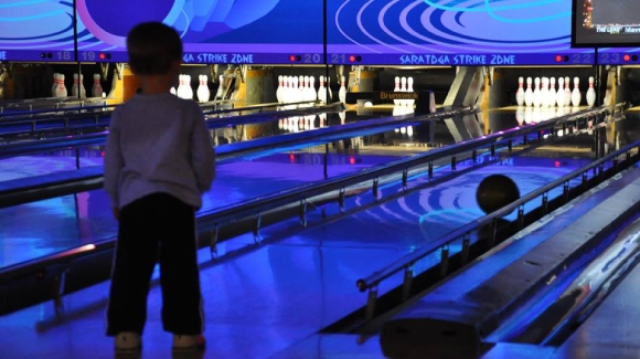 boy getting ready to throw bowling ball down alley