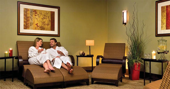 man and woman relaxing on spa lounges