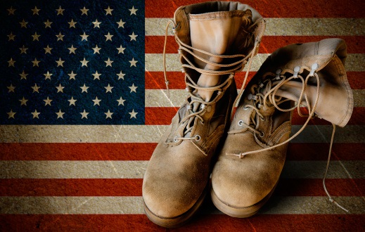 Army boots on sandy flag background
