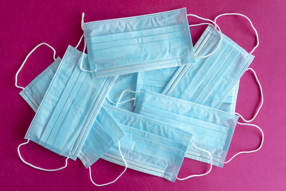 Blue surgical protective masks Blue surgical protective masks on a purple background. Coronavirus (COVID-19) hysteria is leading to mass mask shortages in the beginning of 2020.