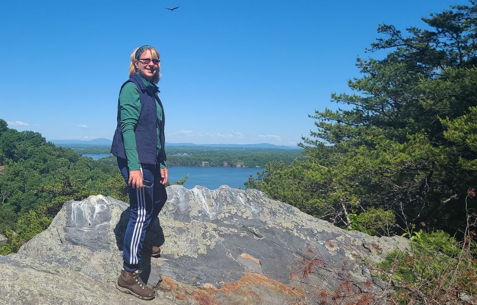 Hiker on top of Smith Mountain with lake in background