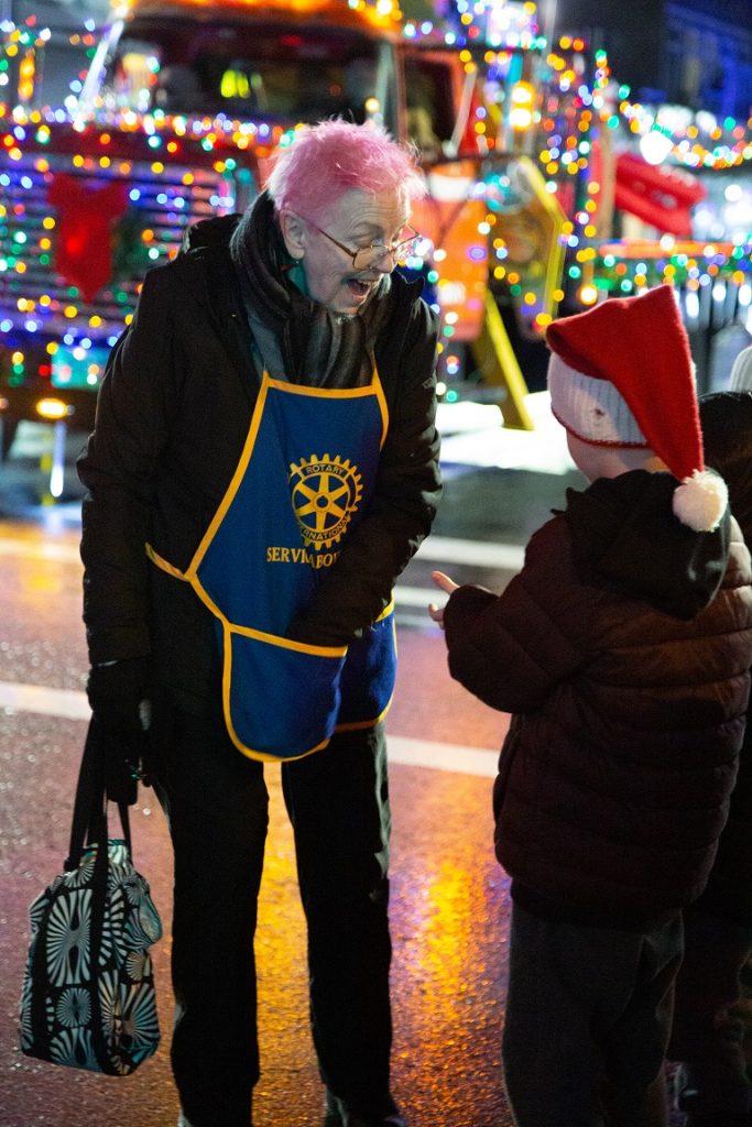 Rotary volunteer and child at Mission's Candlelight Parade