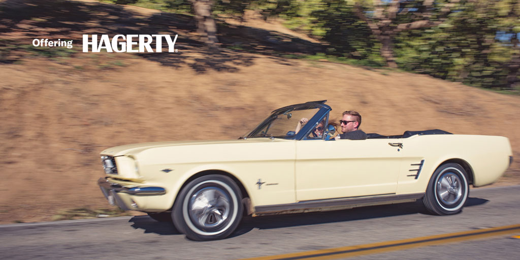 Mustang being driven down road. Hagery insurance logo in top left