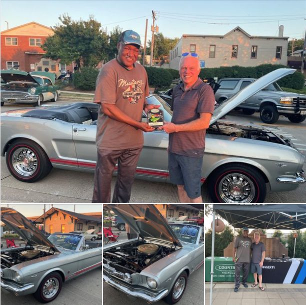 Winner of our Ford Night trophy receiving a plaque, standing in front of a Mustang.