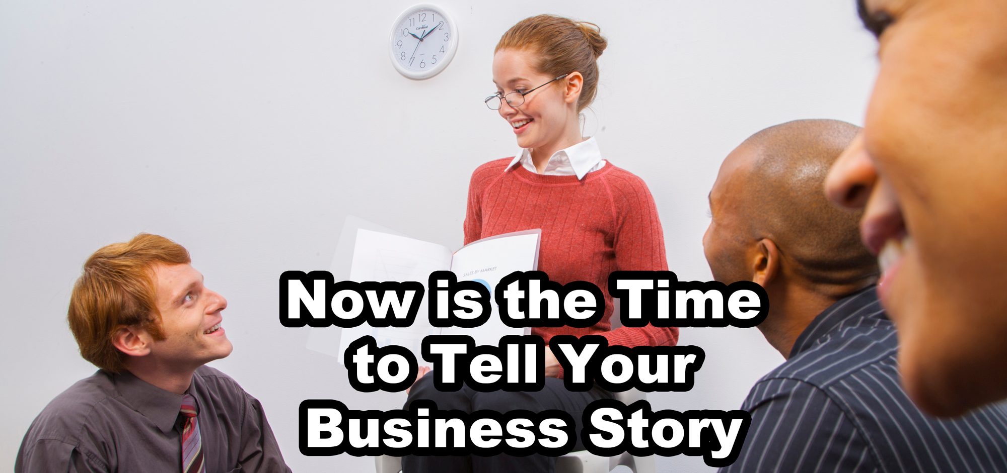 businesswoman reading to other businesspeople - text: Now is the Time to Tell Your Business Story