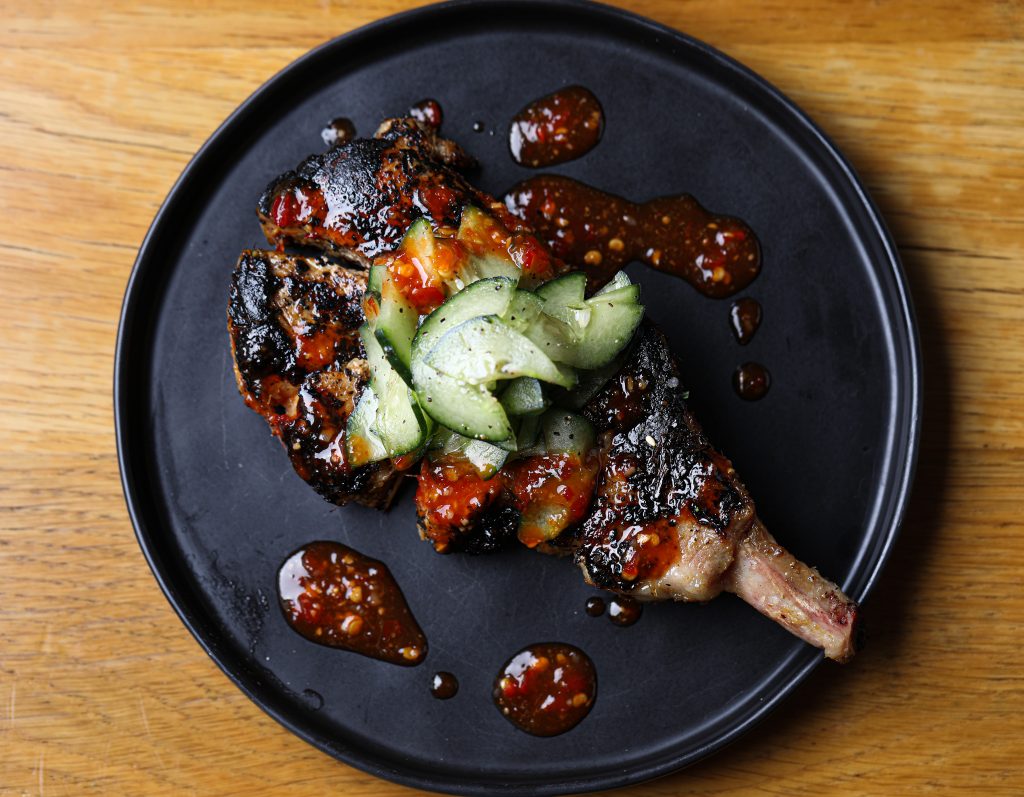 Lemongrass Porkchop topped with red chili oil and a creamy cucumber salad